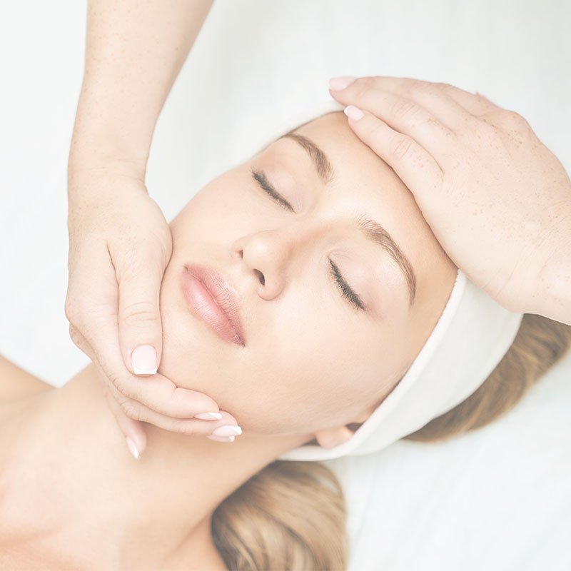A women receiving a Pure Fiji facial with a beauty therapist massaging her face.